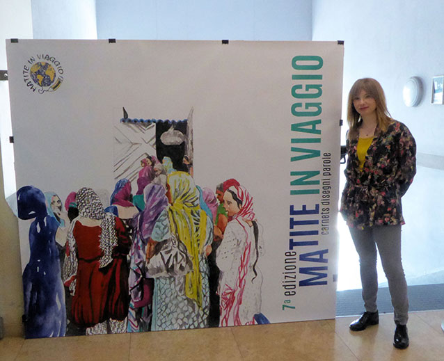 Liuba Gabriele davanti al cartellone d'entrata alla  mostra
